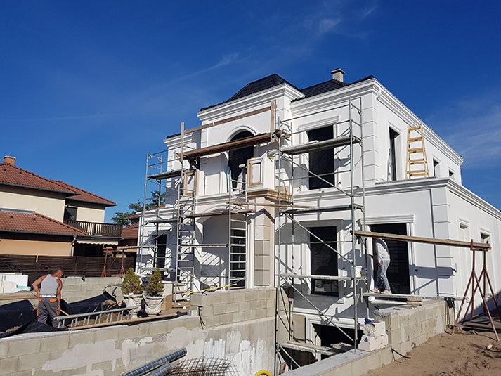 Kérgesített kültéri polisztirol stukkó beépítése új építésű családi ház homlokzatára
